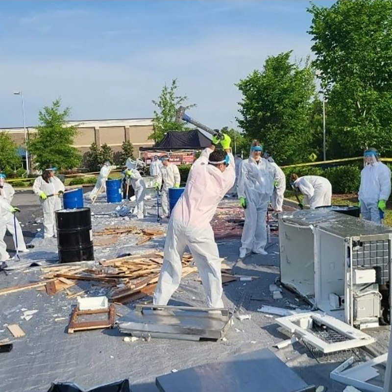 people smashing items in an outdoor mobile rage room